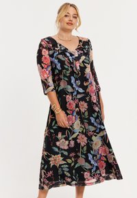 Bloemenjurk met zwarte basis, voorzien van levendige bloemen en vogels, V-hals, ruchesdetail en driekwart mouwen.