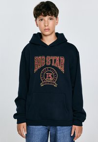 Sudadera de algodón azul marino con un gran gráfico en rojo y dorado que dice "BIG STAR", bolsillo frontal y puños acanalados. Diseño simple y de corte relajado.