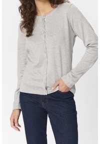 Grauer Langarm-Cardigan aus weichem, geripptem Stoff mit runder Halslinie und Vorderknopfverschluss. Kombiniert mit dunklen Jeans.