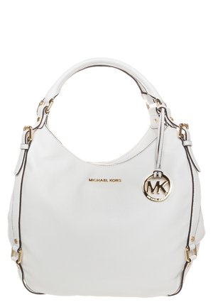 Biała skórzana torebka Michael Kors z pojedynczym górnym uchwytem, złotą plakietką z logo oraz okrągłym zawieszanym ozdobnym elementem MK przy uchwycie.