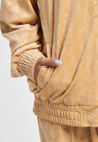 Karl Kani CHEST SIGNATURE MONOGRAM VELVET - Sportinė striukė - sand