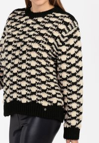 Chunky gebreide trui met een zwart- en crèmekleurig patroon, voorzien van verhoogde bobbels, ronde halslijn en geribde mouwen en zoom.