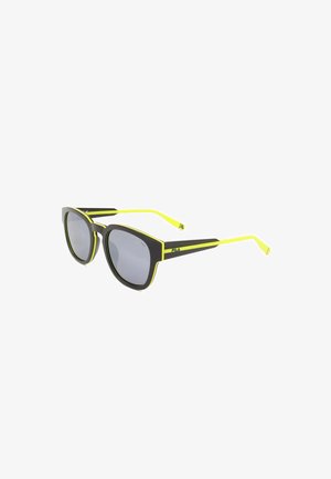 Occhiali da sole neri con lenti grigie e accenti giallo neon lungo i bordi della montatura e le aste, con il logo FILA sulla stanghetta.