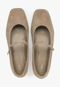 Para beżowych zamszowych butów Mary Jane z kwadratowymi czubkami i cienkimi regulowanymi paskami, widzianych z góry na białym tle.