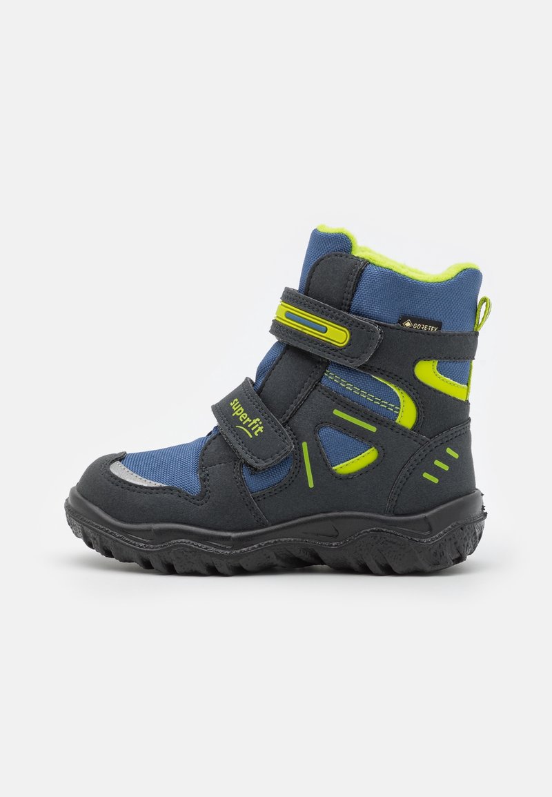 Botte d'hiver bleue et noire pour enfant avec des accents jaune fluo, deux sangles Velcro, semelle texturée et étiquette Gore-Tex étanche.