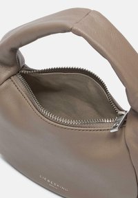 Borsa a tracolla in pelle color tan con manico curvo, chiusura con cerniera e una texture morbida. Fodera interna in un tessuto più chiaro, con il nome del marchio impresso.