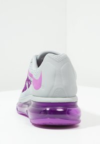 Botté de course Nike gris et violet vu de l'arrière, avec une semelle à coussin d'air violet et un logo Swoosh Nike rose sur le côté.