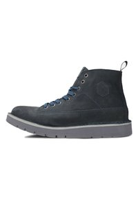 Botă înaltă de culoare albastru închis, realizată din suede, cu talpă de cauciuc gri, detalii hexagonale și sireturi albastre. Suprafață texturată și accente de cusătură.