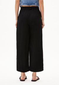 Zwarte wijde broek van lichtgewicht stof, met een elastische tailleband en een relaxed fit, met een zoom net boven de enkel.