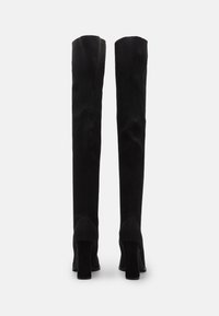 Knee-high zwarte laarzen met hak, gemaakt van ribbelstof met een gestructureerd patroon; ronde neus en chunky hak ontwerp.