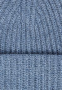 Hellblau gestrickte Mütze mit gerippter Textur. Hergestellt aus weicher Wolle, mit umgeschlagenem Rand und sichtbaren Nähdetails.