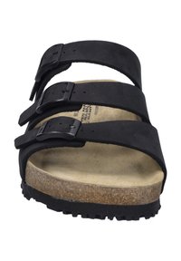 Black three-strap sandal with suede upper and adjustable buckles. Cork footbed and textured rubber outsole for grip.