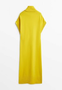 Keltainen neulemekko, jossa on korkea kaulus, lyhyet hihat ja ribbireunus. Suuri tekstuuri ja keskipitkä muoto.