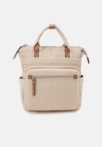 Mochila de lona beige con bolsillo con cremallera en la parte frontal, doble asa superior con acentos de cuero y bolsillos laterales deslizantes, sobre un fondo blanco.