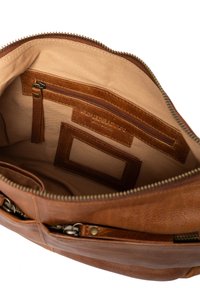 Sac à main en cuir marron avec une doublure en tissu beige. Il comporte plusieurs poches zippées, une étiquette de marque en relief et un extérieur texturé.
