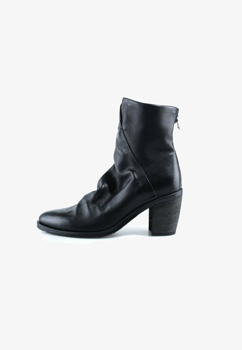 Bottine en cuir noir à talon bloc, fermeture éclair arrière, et texture légèrement froissée, présentée de profil sur fond blanc.