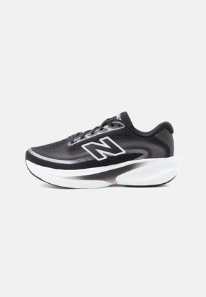 Black and gray athletic shoe with white thick sole and lace-up design, featuring a large "N" logo on the side.