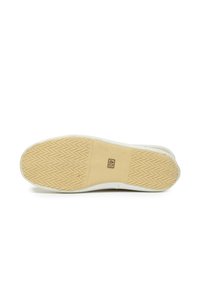 Sneaker blanche avec une semelle en caoutchouc présentant un motif en zigzag. La semelle a un accent beige et indique une taille de 40.