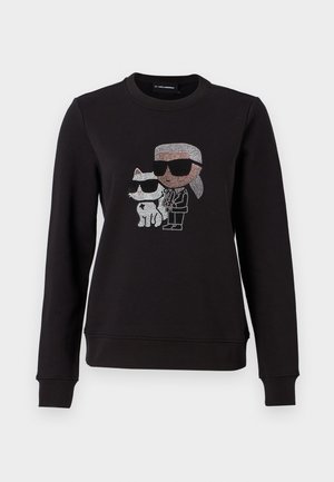 Sweatshirt noir arborant un graphic en strass d'un personnage et d'un chat, tous deux portant des lunettes de soleil. Encolure classique, poignets et ourlet côtelés.