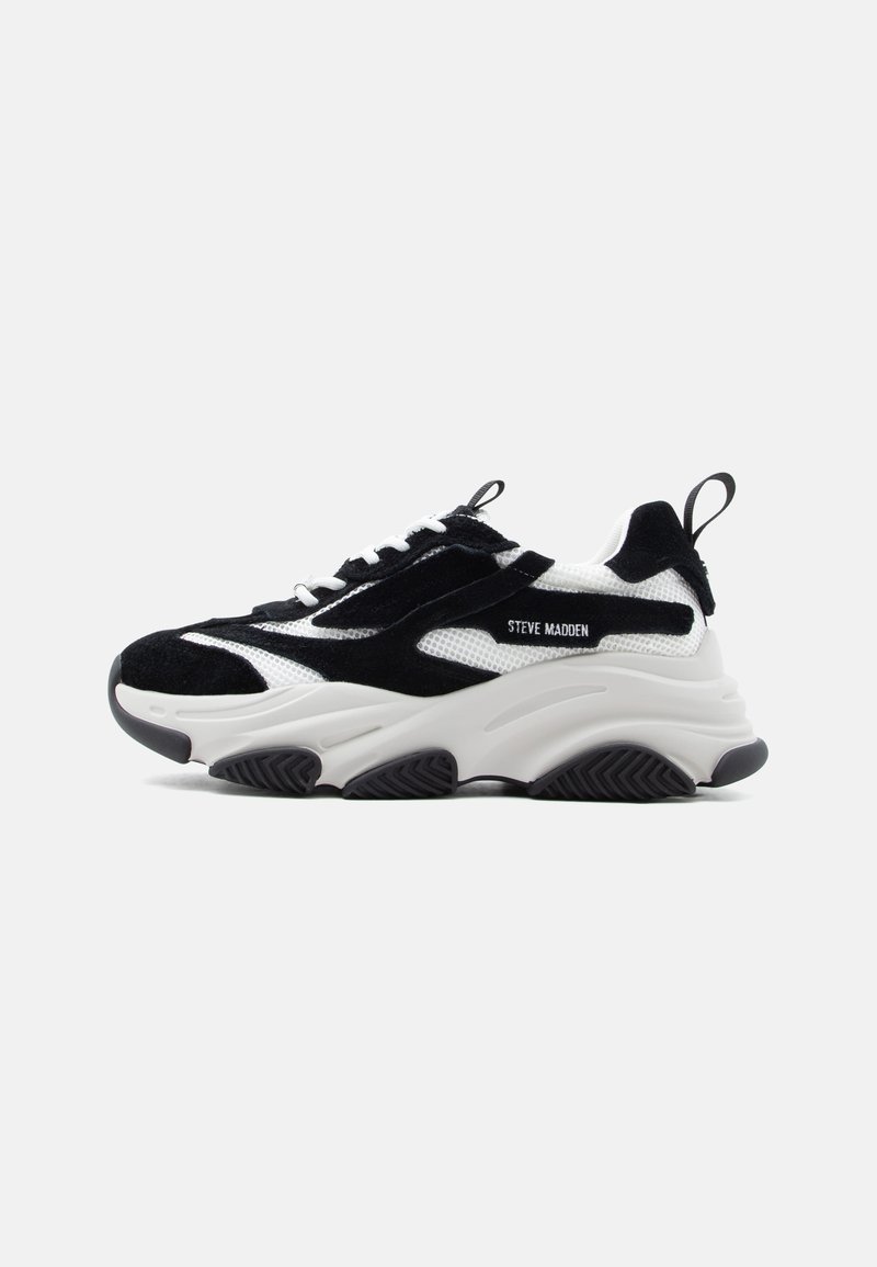 Ασπρόμαυρο αθλητικό παπούτσι Steve Madden με πάνελ από δίχτυ και σουέντ, χοντρή σμιλευμένη σόλα, μαύρες θηλιές και άσπρα κορδόνια, απεικονισμένο από το πλάι.