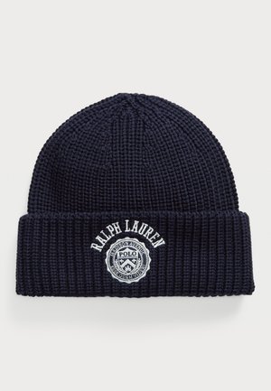 Mørkeblå ribbestrikket lue med brett som har hvit brodert "Ralph Lauren" tekst og en sirkulær Polo-logo-patch.