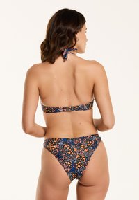 Bikini set s crnom pozadinom sa šarenim cvjetnim uzorkom. Podesiva vezica oko vrata, osnovno kopčanje straga.