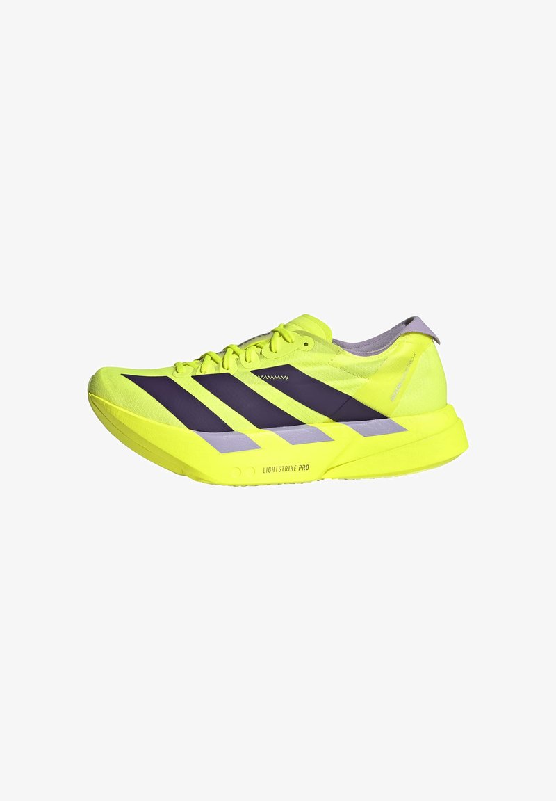 Scarpa da corsa giallo brillante con strisce nere, suola leggera etichettata "Lightstrike Pro," e design basso per una calzata aderente.