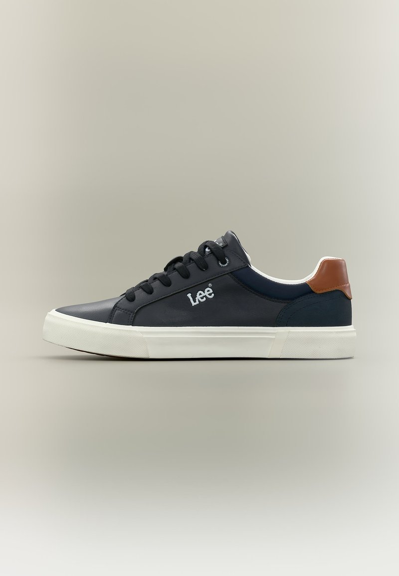 Μαύρο αθλητικό παπούτσι χαμηλού τύπου με λευκή σόλα, μαύρα κορδόνια, καφέ λεπτομέρεια στη φτέρνα και λογότυπο "Lee" στο πλάι.