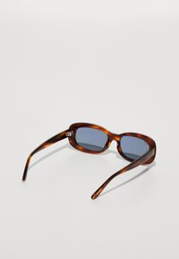 Ochelari de soare tortoise brown cu rame dreptunghiulare, lentile nuanțate în albastru, temple subțiri și accente din metal argintiu.