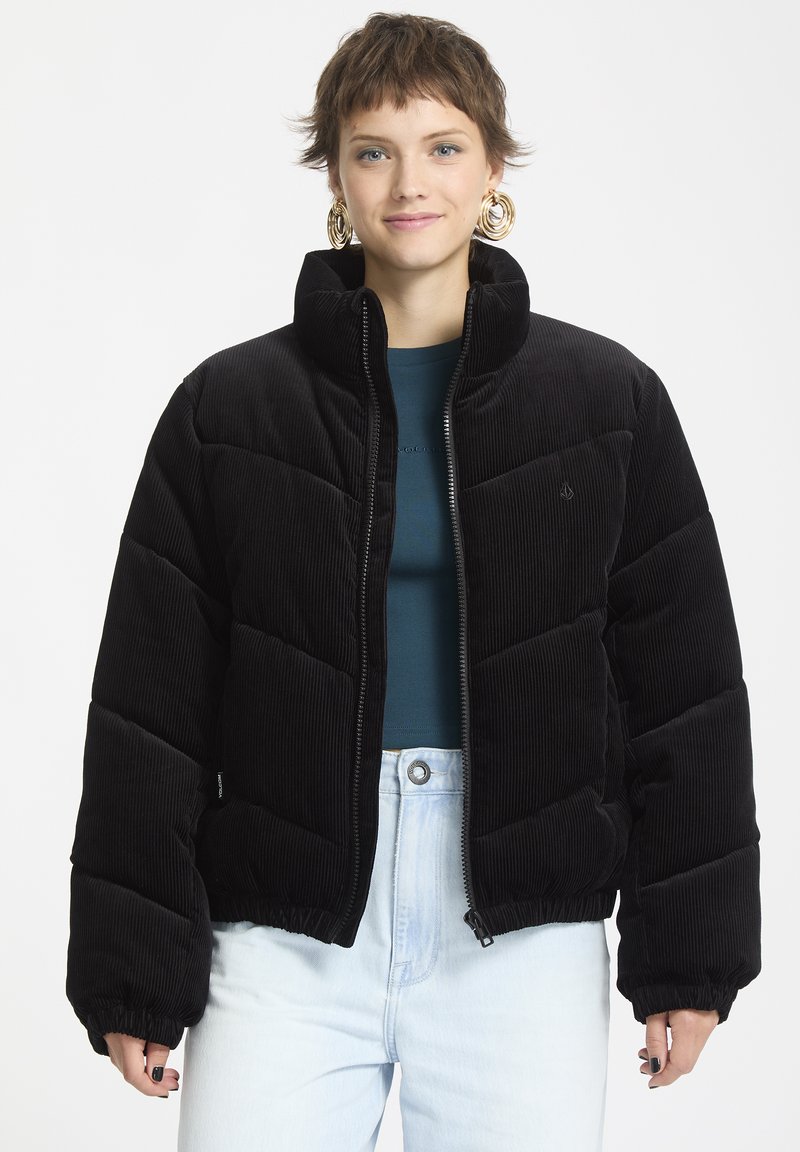 Schwarze Cord-Puffjacke mit hohem Kragen, Reißverschluss vorne und elastischen Bündchen. Verfügt über ein gestepptes Design und ein Logodetail auf der Brust.