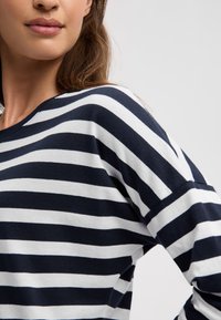 Navy and white striped long-sleeve shirt, featuring a relaxed fit and soft cotton material with contrasting horizontal lines.