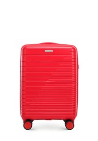 Valise rigide rouge avec des rainures horizontales, roues noires doubles et une poignée de transport supérieure. Présente un emblème de marque métallique à l'avant.