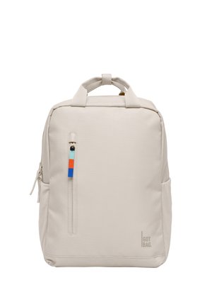 Zaino quadrato beige con manici superiori, una tasca frontale verticale con una cerniera e una linguetta colorata, e il logo "GOT BAG." in basso a destra.