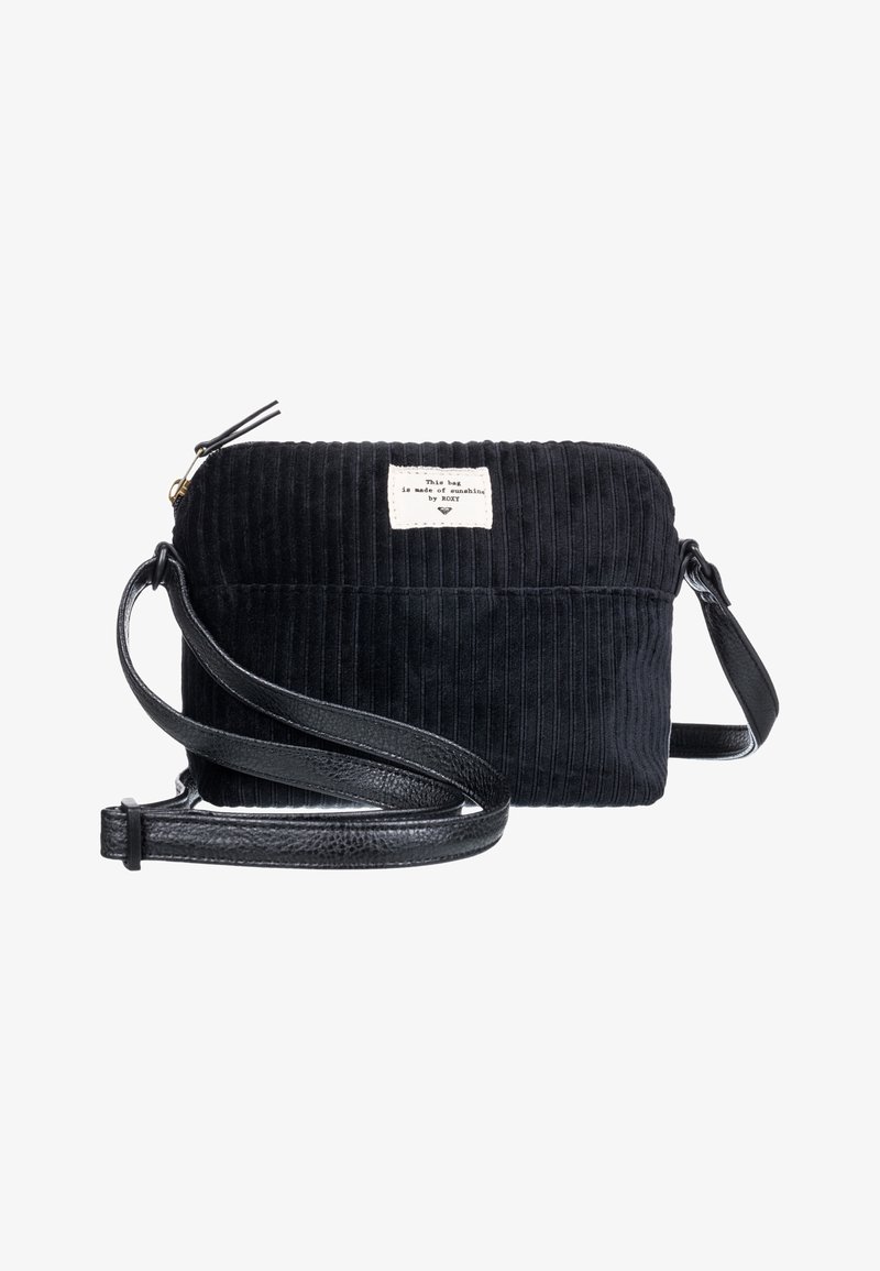 Czarna torba z sztruksu o prostokątnym kształcie, z skórzanym paskiem i małą metką materiałową z przodu. Zamek błyskawiczny na górze.