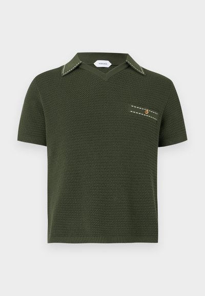 Σκούρο πράσινο πλεκτό κοντομάνικο πουκάμισο με V-λαιμόκοψη, μυτερό γιακά με λευκά ράμματα και μικρό θηλυκό τσέπη στο στήθος με χρυσή λεπτομέρεια κουμπιού.