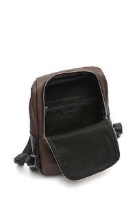 Rjav usnjen nahrbtnik z zadrgo, ki ima teksturiran črn poudar in prostoren notranji del z zadrgo.