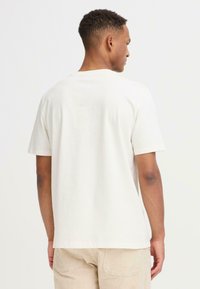 Kortærmet, lysebeige bomulds t-shirt med rund hals, med et simpelt design uden synlige mønstre.