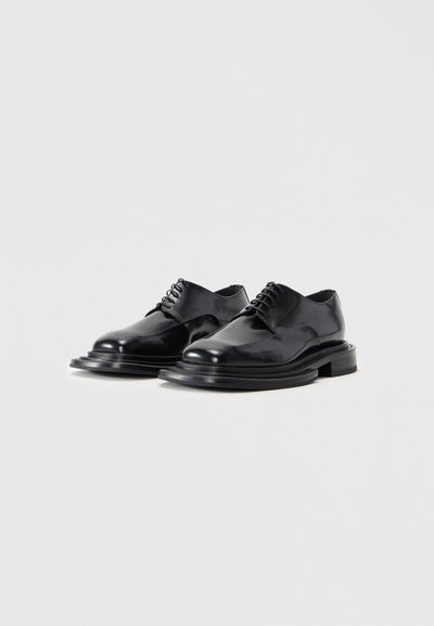 Scarpe eleganti in pelle nera con finitura lucida, caratterizzate da una punta rotonda, design con lacci e una suola spessa e texture.