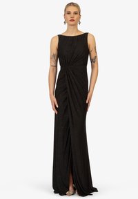 Schwarzes bodenlanges Kleid mit einem eleganten Design, das ein verdrehtes Frontdetail, eine schimmernde Textur und einen subtilen Glanz aufweist.