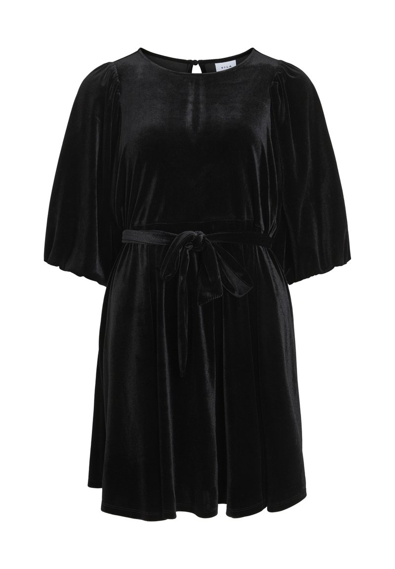 Svart sammetsklänning med korta puffärmar, rund halsringning och midjeband. Har en nyckelhålöppning bak och en flödande kjol.