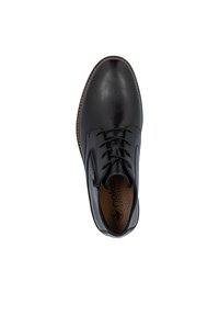 Zapato de cuero negro con punta redonda, cordones y suela en contraste color marrón claro. Presenta una textura suave y plantilla con marca.