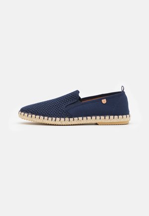 Navy slip-on shoe with a mesh upper, espadrille-style jute sole, and a tan accent. Features a rounded toe and stitched detailing along the sole.