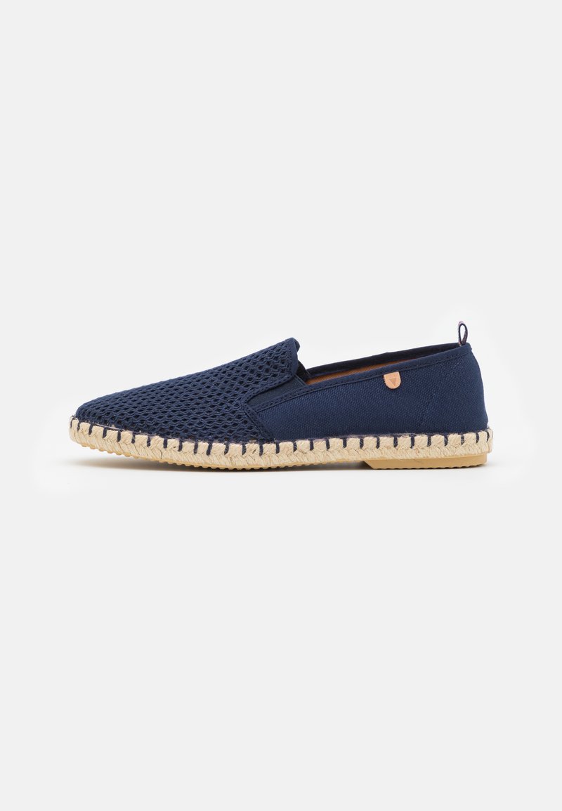 Navy slip-on shoe with a mesh upper, espadrille-style jute sole, and a tan accent. Features a rounded toe and stitched detailing along the sole.