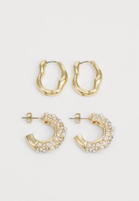 Two pairs of gold-tone hoop earrings. One pair features a smooth, wavy design; the other is adorned with pearls and rhinestones.