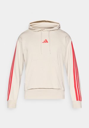 Sudadera con capucha beige con un bolsillo canguro en la parte delantera, detalles de tres rayas rojas en las mangas y un pequeño logo rojo en el pecho. Tejido de mezcla de algodón.