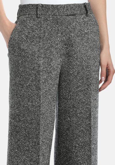 Hlače širokih nogavica od teksturirane crno-bijele tkanine, sa ravnim prednjim dijelom, bočnim džepovima i glatkim pojasom.