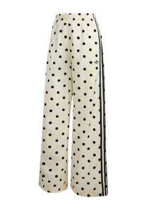 Pantalon blanc à jambes larges avec des pois noirs, taille élastique et bandes Adidas noires avec logo sur le côté.