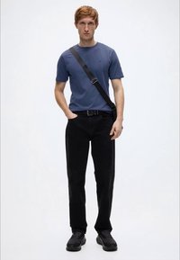 Ανδρικό εφαρμοστό μπλε μπλουζάκι, μαύρο παντελόνι με ίσια γραμμή και μαύρα αθλητικά παπούτσια. Απλός σχεδιασμός με στρογγυλή λαιμόκοψη και τσάντα χιαστί.