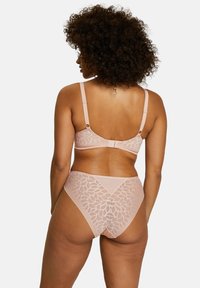Lace-trimmed bra and brief set in soft peach fabric, featuring leaf pattern and adjustable straps; smooth texture with a delicate design.