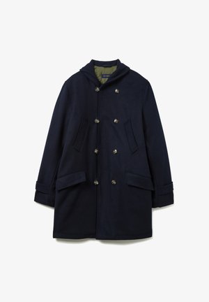 Marineblauwe wollen jas met een capuchon, dubbelgeknoopte sluiting, twee voorzakken en een gladde textuur. De binnenvoering is groen.